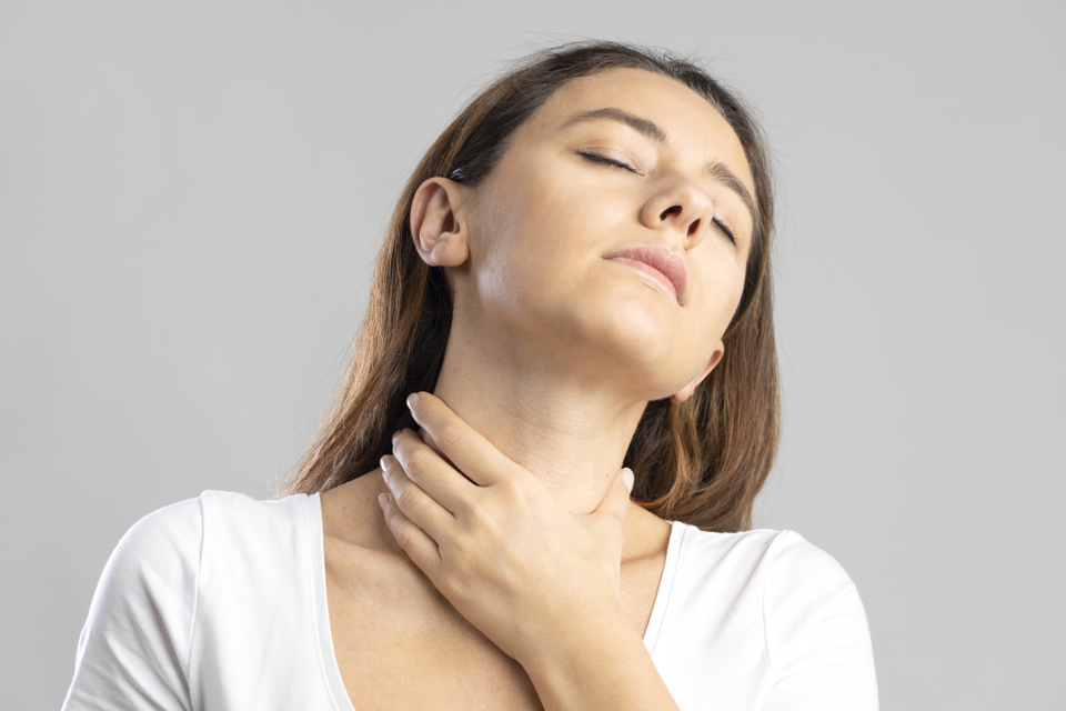 Kvinde holder på sin hals 