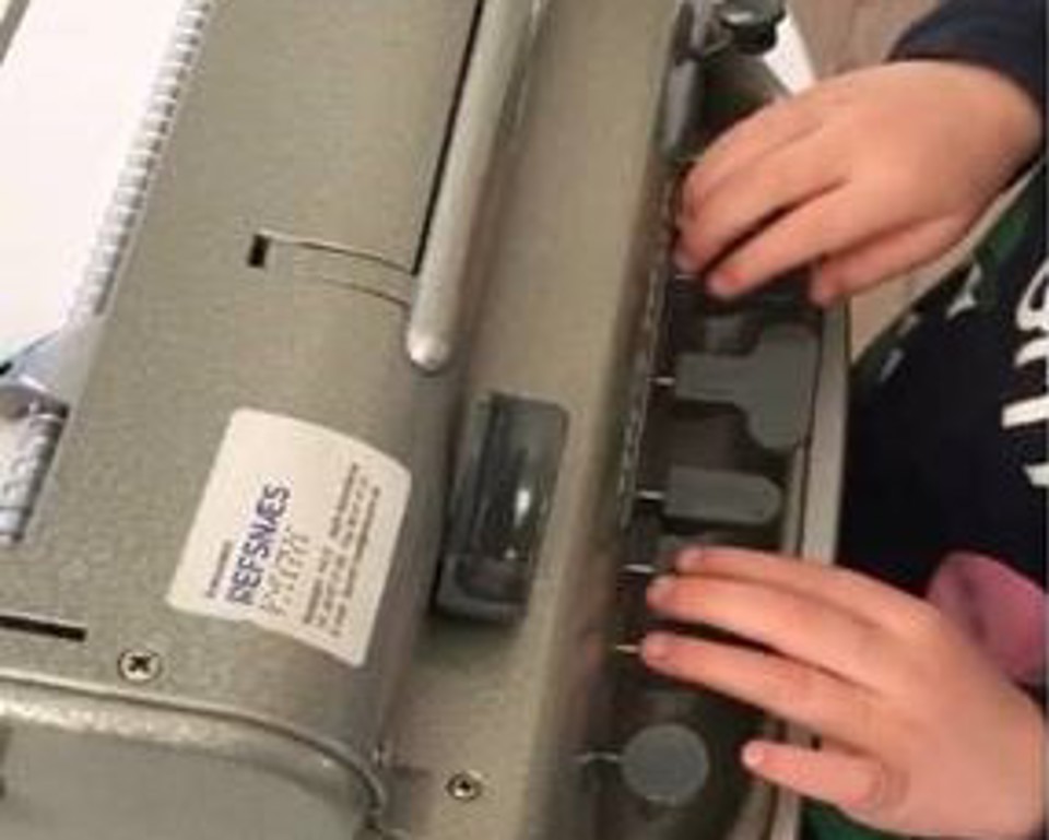 Lille dreng skriver på Perkinsmaskine