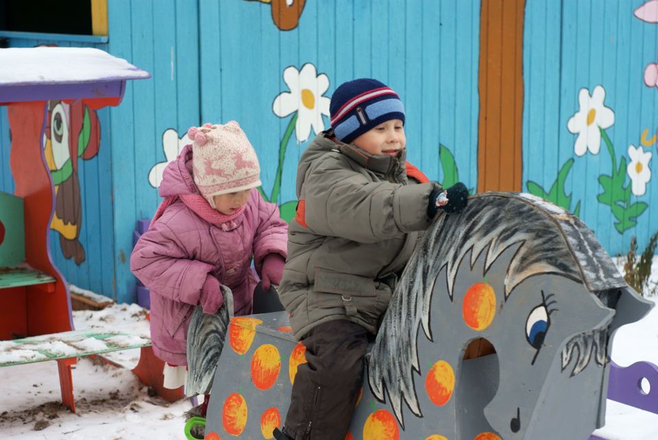 To børn der leger uden for på en træhest