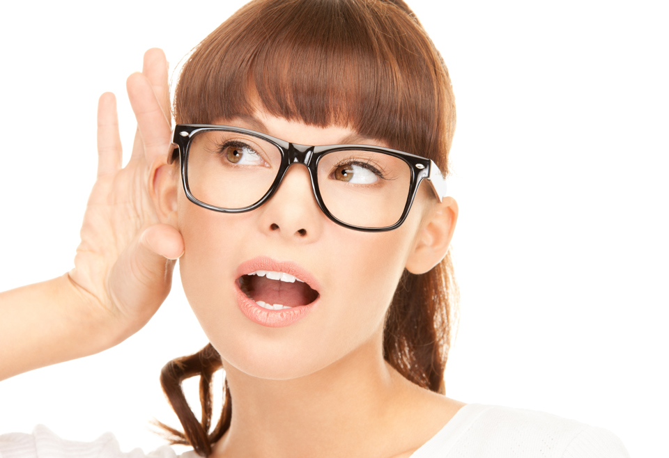 Mørkhåret, ung kvinde med briller, holder bag sit ene øre