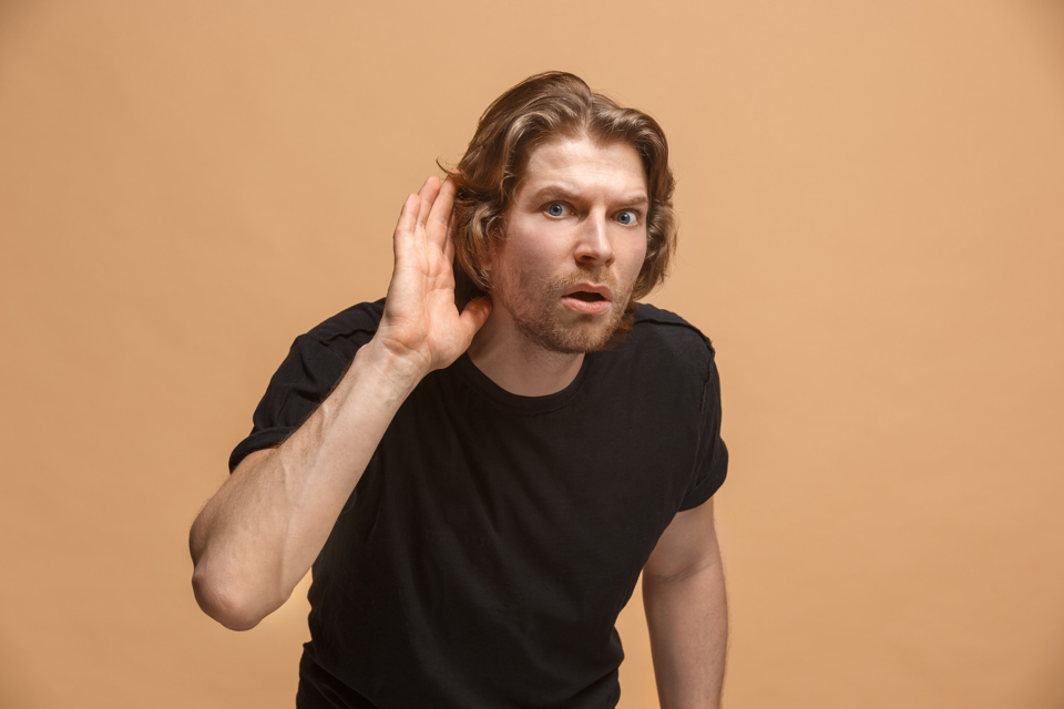 yngre mand holder sig bag øret. Han har et spørgende ansigtsudtryk